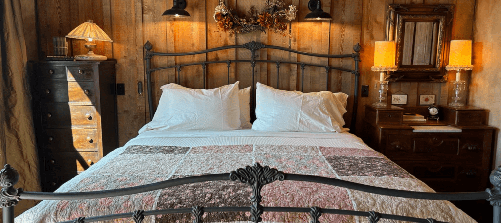 Inn_at_Sunset_Mill_Ranch_Texas_Hill_Country_Hotel_Granary_Room_bed - Inn at Sunset Mill Ranch Image of king iron bed with homemade quilt in granary room at the Inn at Sunset Mill Ranch