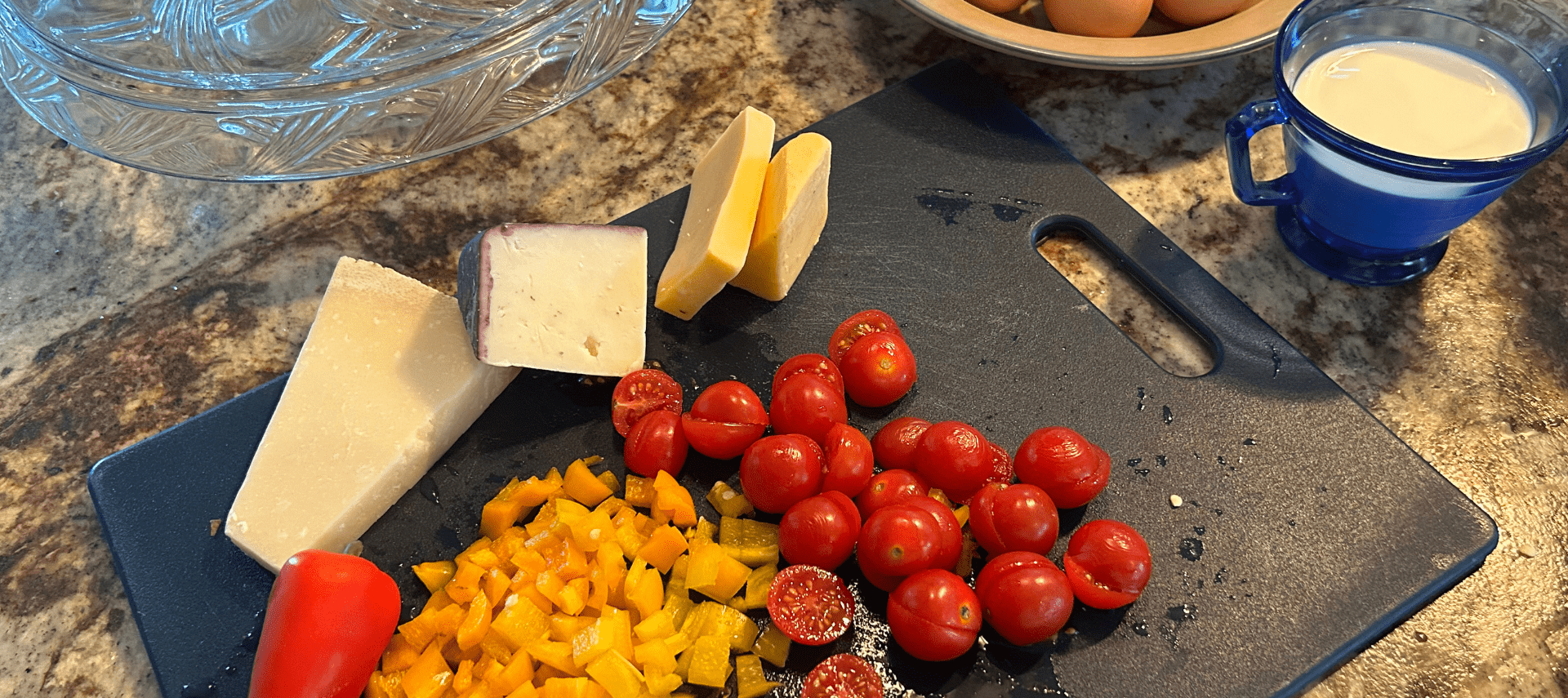 Image of tomatoes pepper and cheese as omelet ingredients on cutting board