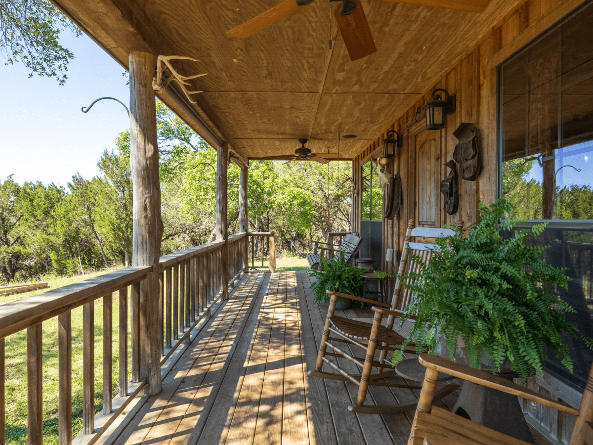 Image of front porch with two rocking chairs and green fern at Cabin at Inn at Sunset Mill ranch