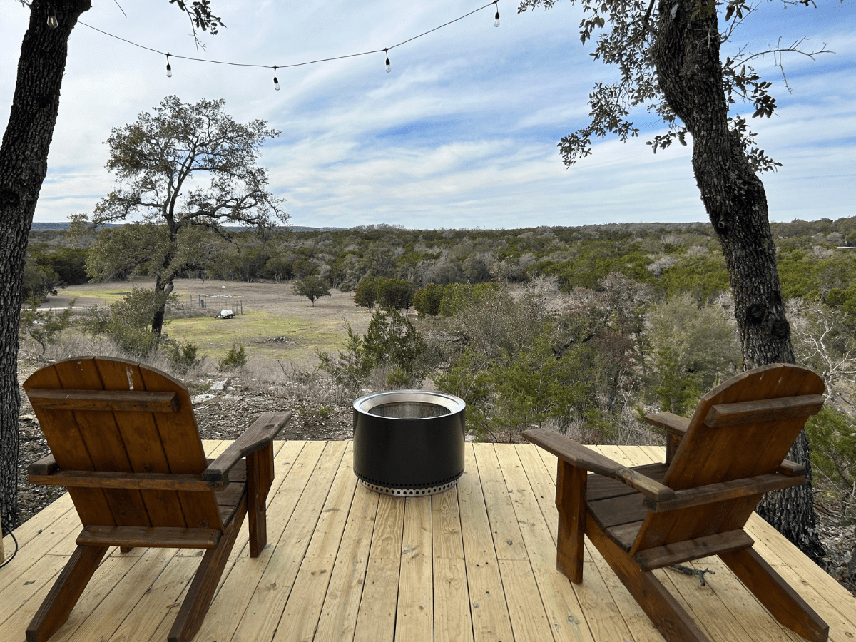Image of two adirondak chairs and firepit overlooking view in Texas Hill Country