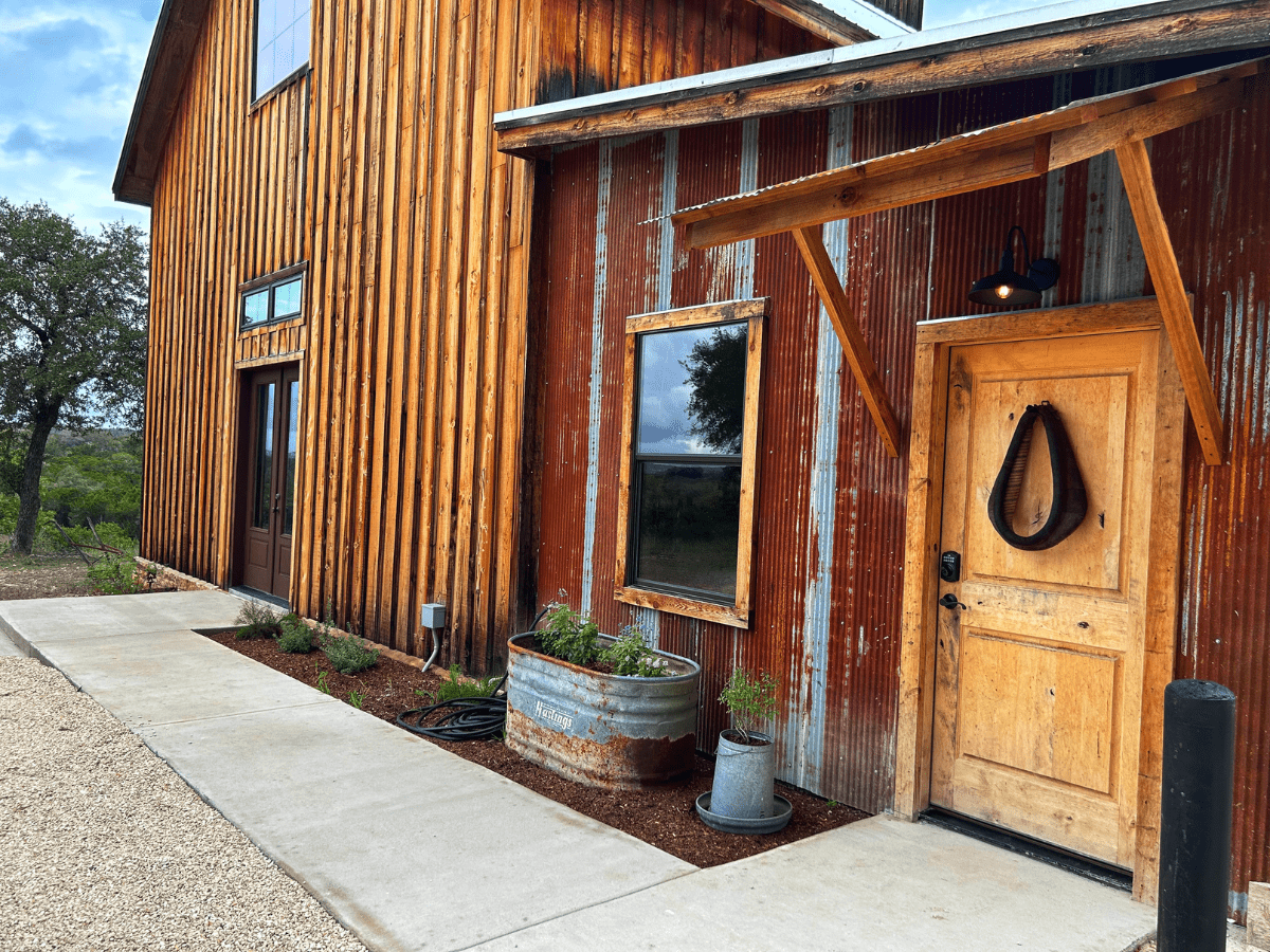 Inn_at_Sunset_Mill_Ranch_Wimberley_Hotel_granary_room - Inn at Sunset Mill Ranch Image of exterior entrance to luxury hotel room in barn on texas ranch