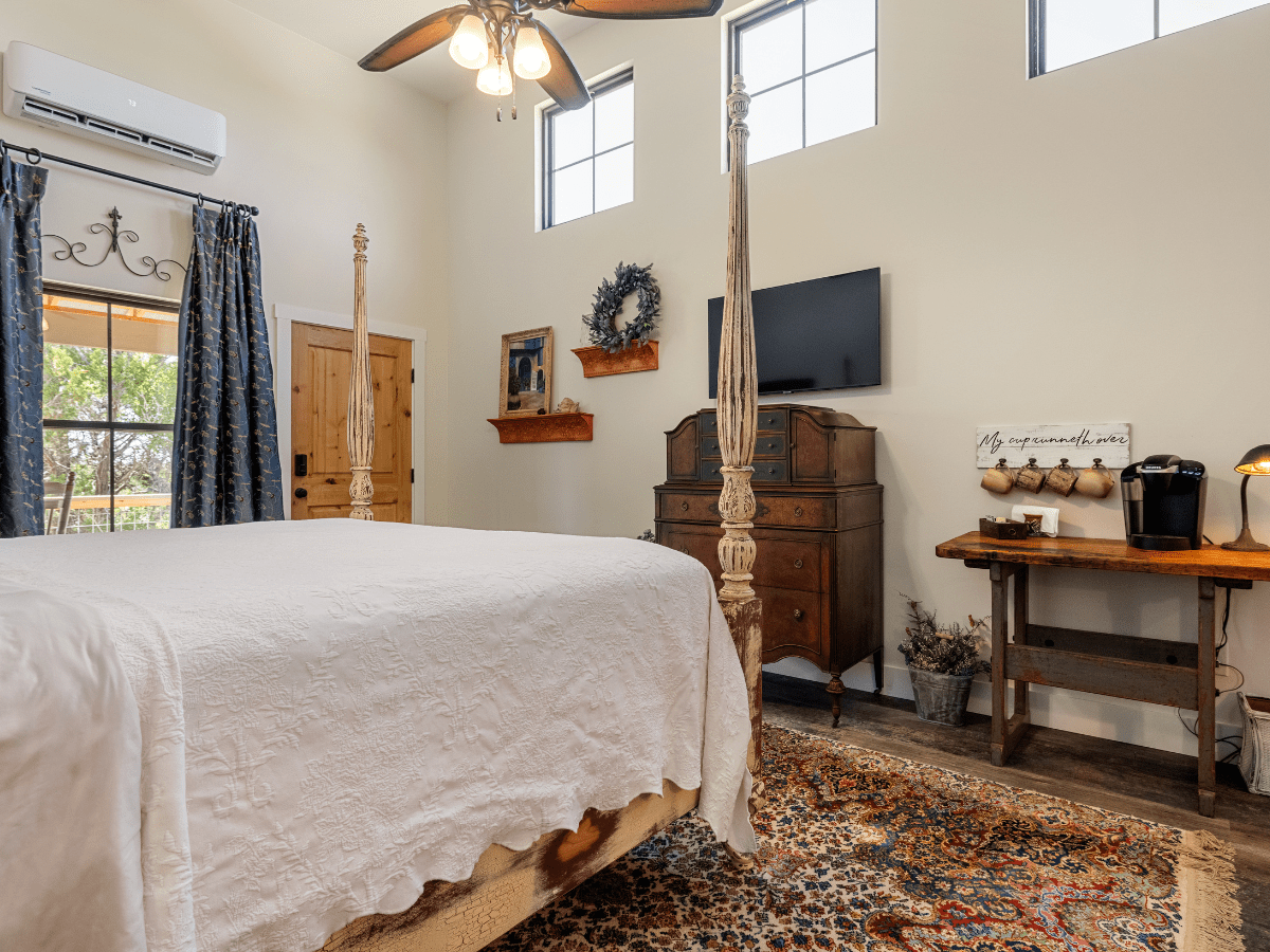 Image of four poster king bed in lodging room in Wimberley texas at Inn at Sunset Mill Ranch