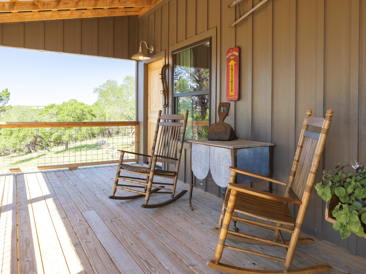 Inn_at_Sunset_Mill_Ranch_Wimberley_Hotel_mill_room (2) - Inn at Sunset Mill Ranch Image of two rocking chairs on deck at texas lodging inn at sunset mill ranch