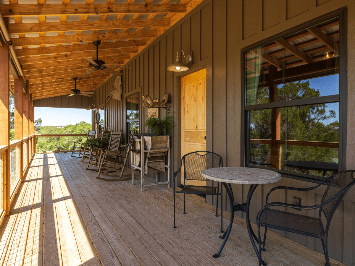 Inn_at_Sunset_Mill_Ranch_Wimberley_Hotel_sunset_room (2) - Inn at Sunset Mill Ranch Image of iron chairs and bistro table on cute deck in Texas hill Country