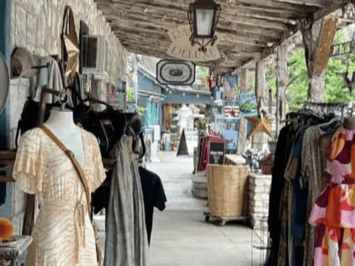 Inn_at_Sunset_Mill_Ranch_Wimberley_Lodging_shopping_and_Antiquing - Inn at Sunset Mill Ranch image of patio walkway filled lined with dressings and retail shops in downtown Wimberley