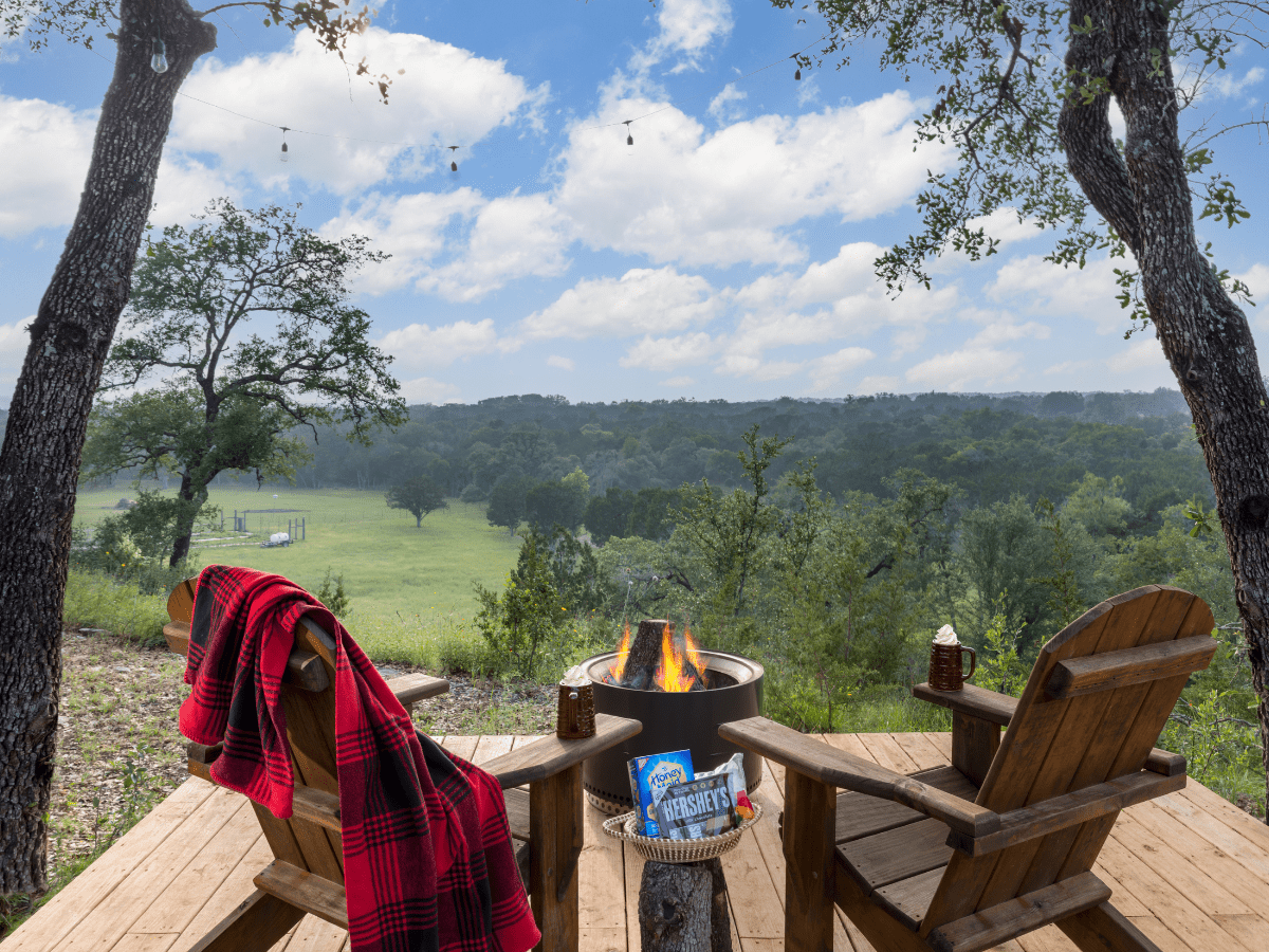 Inn_at_Sunset_Mill_Ranch_Wimberley_Hotel_deck - Inn at Sunset Mill Ranch Image of two adirondak chairs and firepit on deck overlooking views in Texas Hill Country