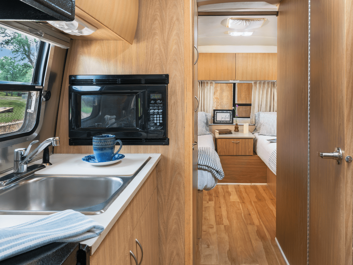Inn_at_Sunset_Mill_Ranch_Wimberley_Hotel_glamper 2 - Inn at Sunset Mill Ranch Image of airstream glamper sink with view into twin bedroom at Texas Hill Country bed and breakfast