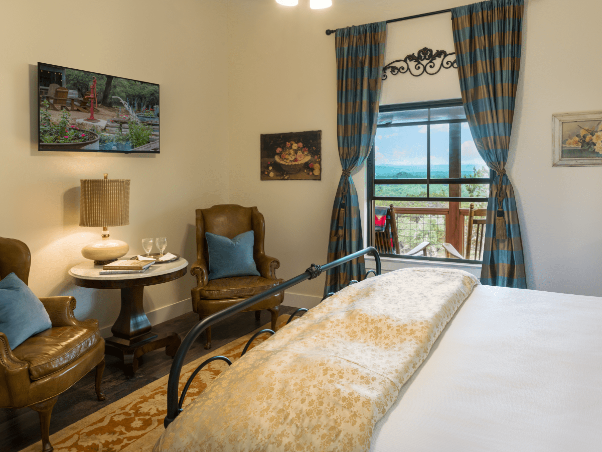 Inn_at_Sunset_Mill_Ranch_Wimberley_Hotel_sunset_room 3 - Inn at Sunset Mill Ranch Image of bed with picture window in background at Texas Hill Country hotel